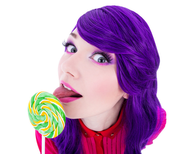 смешная женщина с фиолетовые волосы, облизывая леденец, изолированные на белом фоне - Фото, изображение