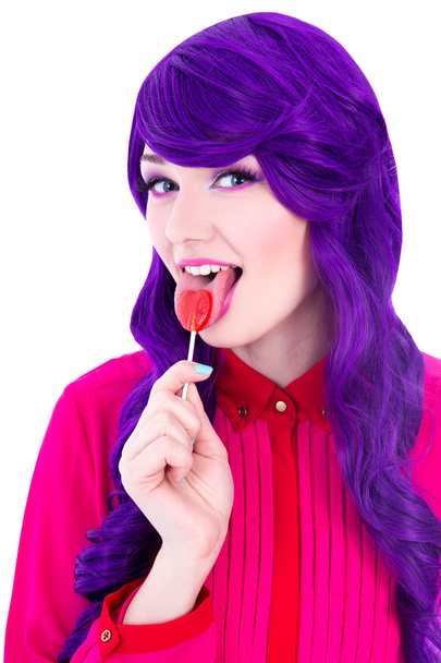 Ritratto di donna con capelli viola parrucca che lecca lollipop isolato - Foto, immagini