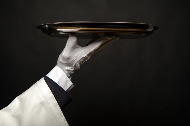 Σερβιτόρος χέρι κρατά θήκη πάνω από το μαύρο φόντο. - Φωτογραφία, εικόνα
