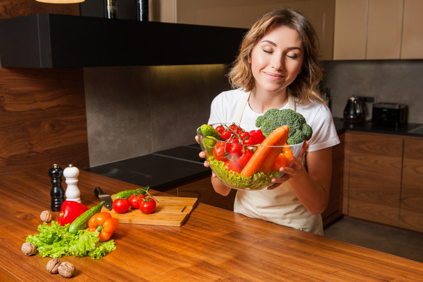 Picture of woman in the kitchen holding a plate salad - Fotoğraf, Görsel