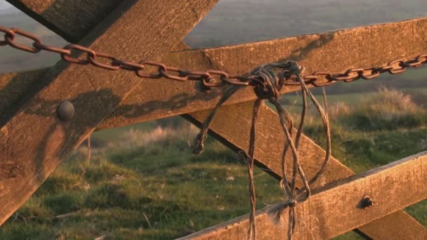 La luz de la noche destaca una cadena que se balancea sobre una puerta en la campiña de Shropshire, Reino Unido
. - Metraje, vídeo