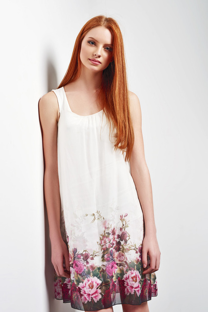 Beautiful female in sleeveless flower print summer dress - Photo, Image
