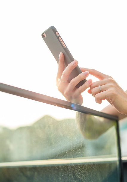 жінка використовує мобільний телефон на відкритому повітрі
 - Фото, зображення