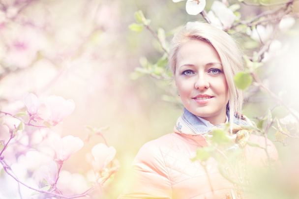 Beautiful Spring Girl with the magnolia flowers - Foto, Bild