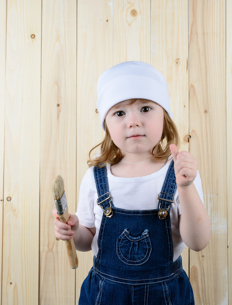 Menina posando com uma escova na parede de madeira
 - Foto, Imagem