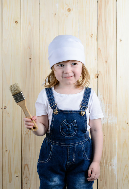 Girl posing with a brush in wooden wall - Fotoğraf, Görsel