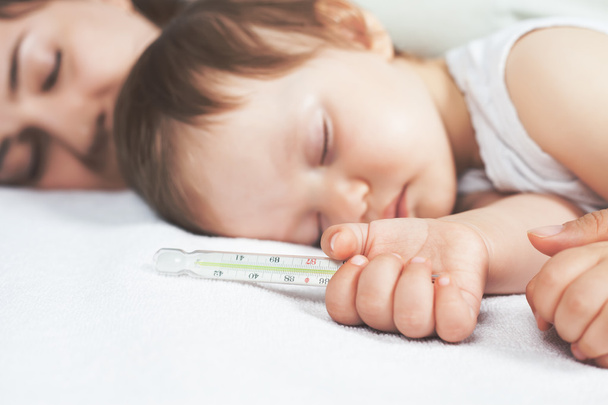 Child has a high temperature or fever, using a thermometer - Fotoğraf, Görsel