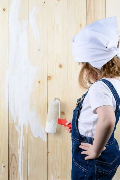 Little girl paints a wooden wall - Photo, Image