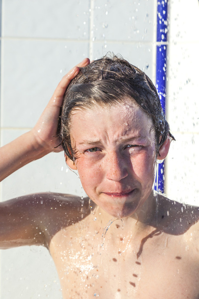 Boy has fun unter the pool shower - Фото, изображение