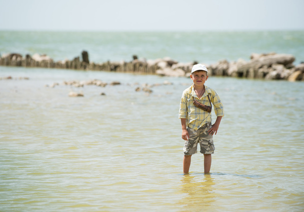 Мальчик со шпилькой стоит в море - Фото, изображение