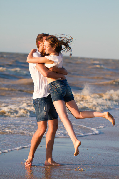 Happy young couple in love have fun on beautiful beach at beauti - Фото, изображение