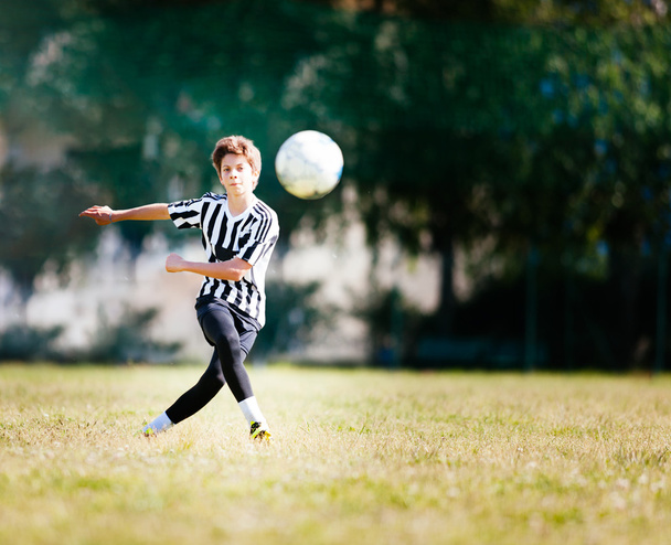 Boy playing football in a soccer field - Photo, Image