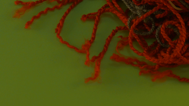 Cabeça de fios em ângulo Lã de fio na tela verde Fios coloridos estão se movendo pedaços de fios cortados Alguém está puxando um fio Remove-o mais perto
 - Filmagem, Vídeo
