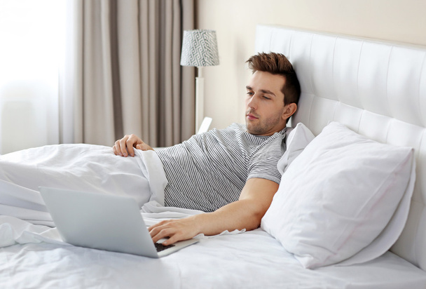 Man lying in bed with laptop - Photo, image