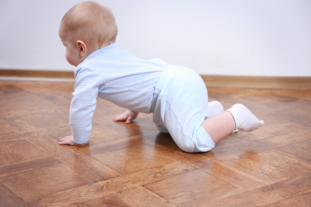 Crawling baby on the wooden floor - Fotó, kép