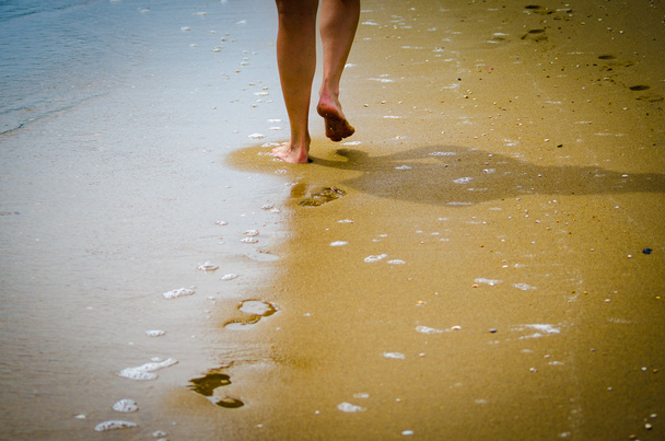 Mooie vrouw een voet in het strand - Foto, afbeelding