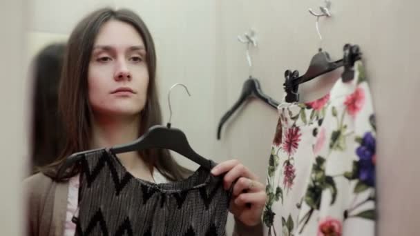 Beautiful girl trying clothes in a fitting room - Video