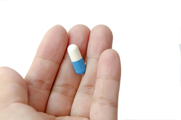pillen capsule in de hand op witte achtergrond  - Foto, afbeelding