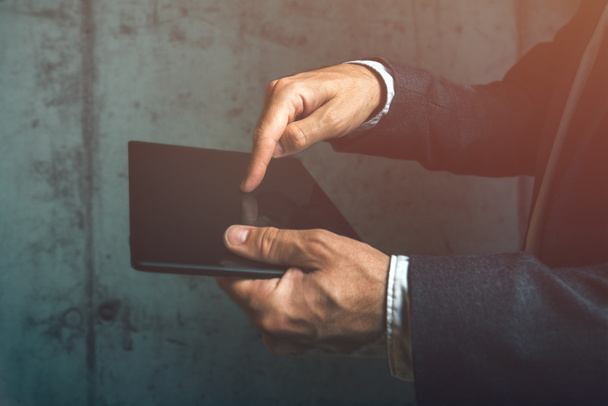 Неузнаваемый бизнесмен, использующий цифровой планшетный палец нажатием
 - Фото, изображение