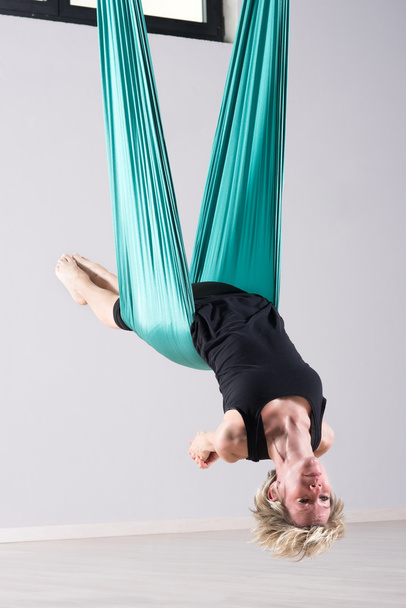 Female athlete doing aerial yoga arm stretches - Photo, Image