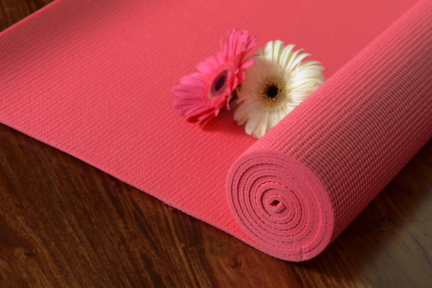 Close-up de tapete de Yoga rosa no piso de madeira marrom
 - Foto, Imagem
