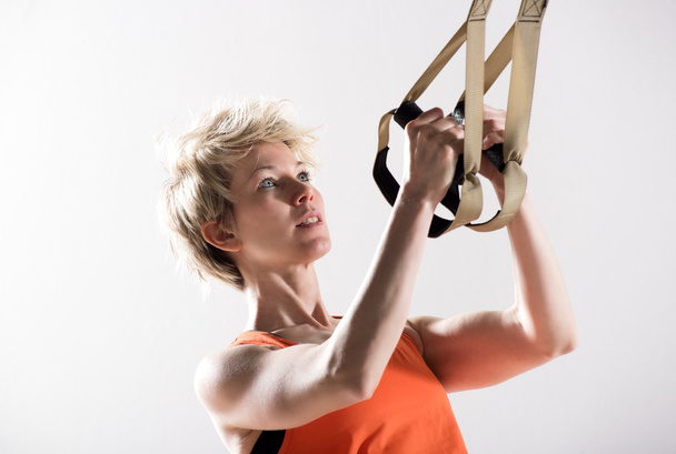 Atletische vrouw trekken fitness koorden - Foto, afbeelding