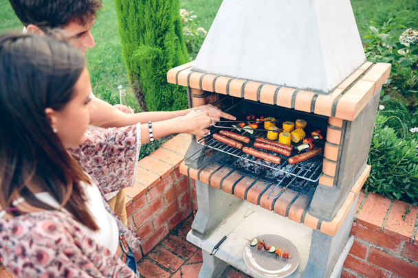 Друзья готовят барбекю на летней вечеринке
 - Фото, изображение