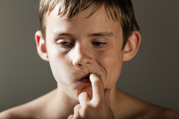 Young Boy Deep in Thought While Sucking on Finger - Foto, afbeelding