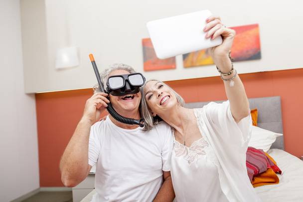 mature happy couple takes a selfie joking in hotel room - Photo, image