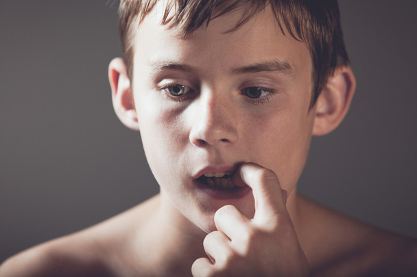 Širá dospívající chlapec vyzvedání zubů prstem - Fotografie, Obrázek