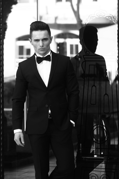 Young man in suit near glass door - Zdjęcie, obraz
