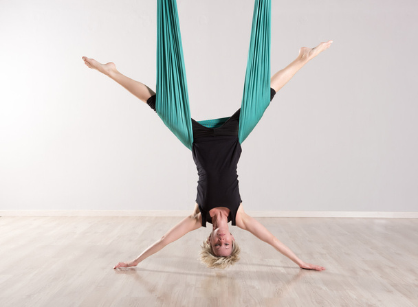 Simple femme à l'envers faisant des divisions de yoga aérien
 - Photo, image
