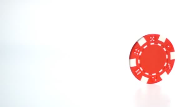 red poker chip turning on white surface  in slow motion - Felvétel, videó