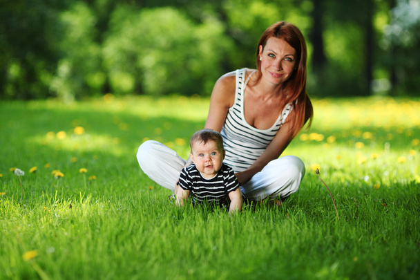 Mother and daughter on the green grass - Photo, image