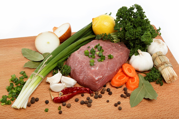 Сырое мясо, овощи и специи изолированы на деревянном столе
. - Фото, изображение