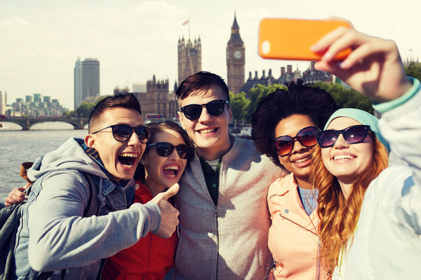 smiling friends taking selfie with smartphone - Foto, Imagen