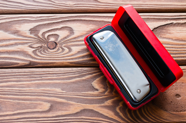 harmonica in a red box on a wooden background - Foto, Bild