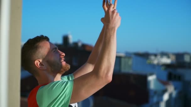 young man making selfie on a balcony slow motion - Metraje, vídeo