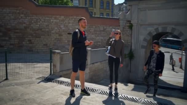 tres turistas caminando por la ciudad y tomando fotos en cámara lenta
 - Imágenes, Vídeo