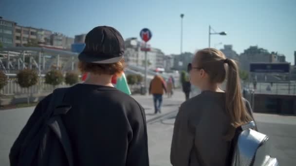 Terug Bekijk drie jonge mensen lopen in de stad centrum slow motion - Video