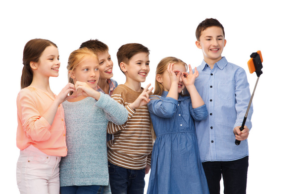 happy children with smartphone and selfie stick - Fotó, kép