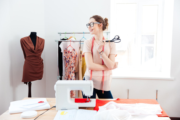 Cheerful woman seamstress with scissors standing in design studio - Foto, immagini
