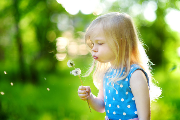 Little girl blowing off a dandelion - Foto, afbeelding