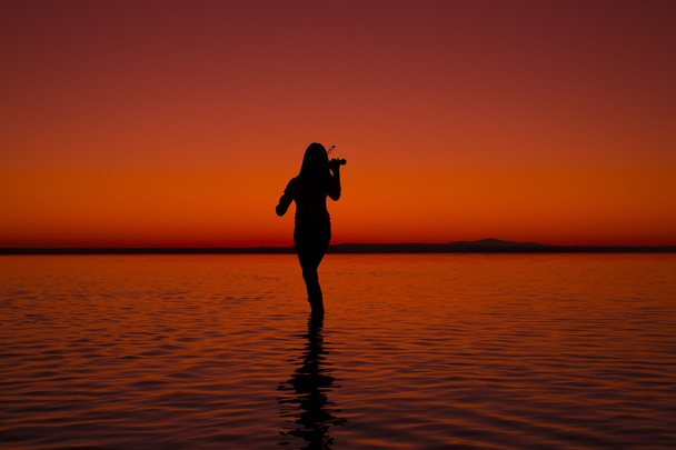 Turquia, mulheres silhueta violino Salt lake ao pôr do sol
 - Foto, Imagem
