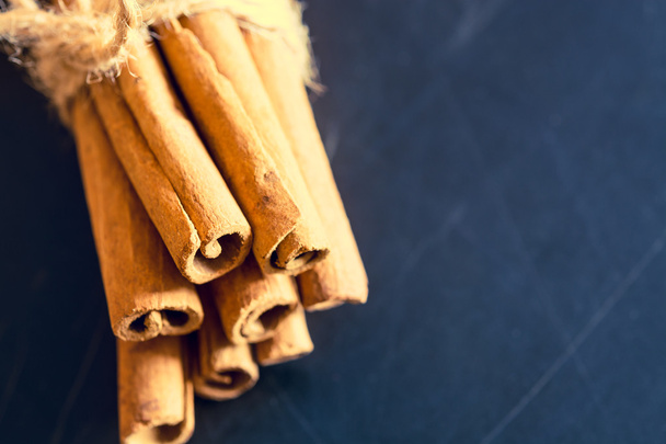 Bunch of cinnamon sticks on black background - Photo, Image