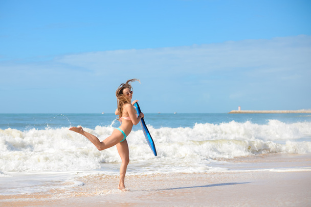 Красива серфер молода леді на пляжі з бодібілдингом, готова до веселощів
 - Фото, зображення