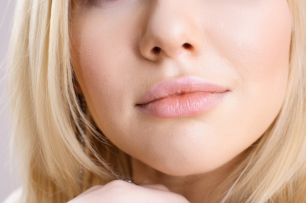 Nahaufnahme eines jungen blonden Mädchens mit vollen Lippen - Foto, Bild