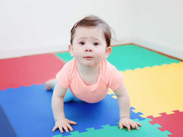 Portrait of cute adorable Caucasian smiling baby boy girl lying on floor in kids room looking in camera, natural window light, lifestyle - Photo, Image