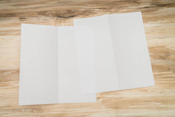 Bifold papel de plantilla blanco sobre textura de madera
 - Foto, imagen