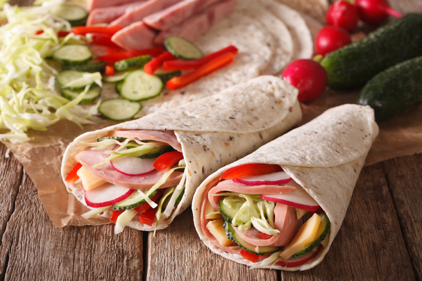 Rollo sándwich lleno de jamón, queso y verduras frescas cerrar
 - Foto, Imagen